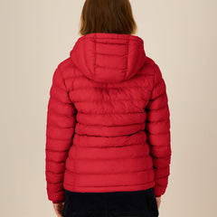 Red sustainable puffer jacket worn by a woman on a beige background