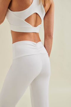 Back view of woman wearing white sustainable yoga leggings and eco-friendly sports bra from Wellicious — circular, non-toxic, microplastic-free activewear