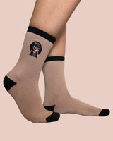 Beige socks with black accents and a dog illustration on a beige background
