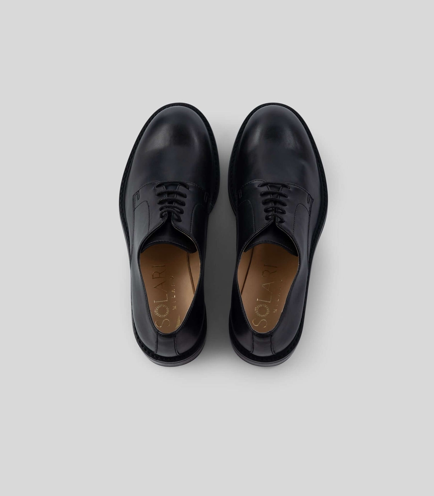 Vegan Derby - Woman in black leather, featuring an open lacing system, perfect for formal and casual events.