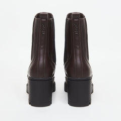 Pair of brown vegan leather boots with black soles on a white background