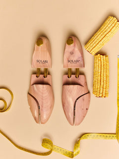 Premium cedar wood Shoe Trees displayed on a beige background with measuring tape and yellow corn decor.