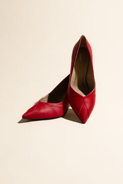 Pair of vegan red high heels on a beige background